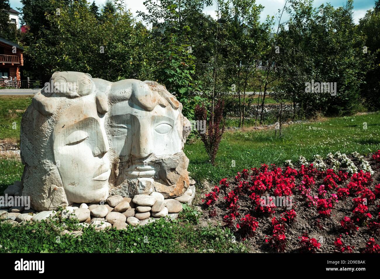 Bukovel, Ucraina - Luglio 2020: Scultura tipica della coppia Ucraina in un villaggio rurale. Due grandi statue a testa circondata dalla natura. Simbolo dell'amore all'aperto Foto Stock