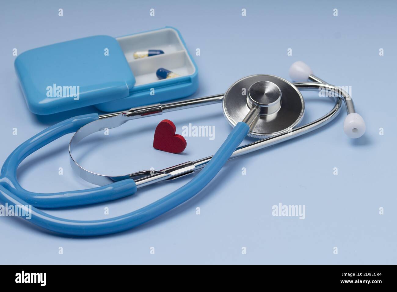 Cuore rosso con stetoscopio su sfondo blu Foto Stock