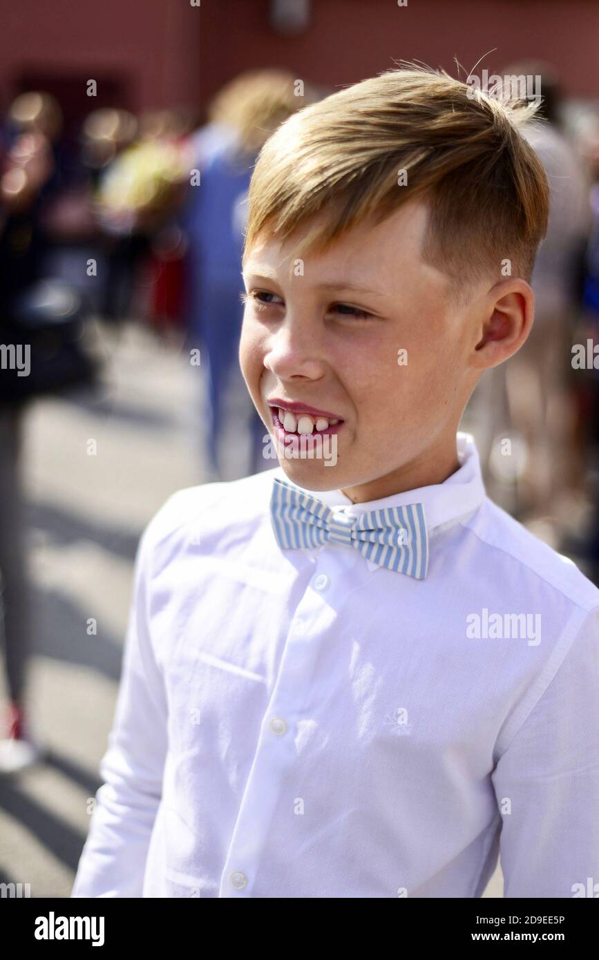 Un ragazzo in una camicia bianca e con una cravatta ad arco. Inizio dell'anno scolastico. Primo piano. Foto Stock