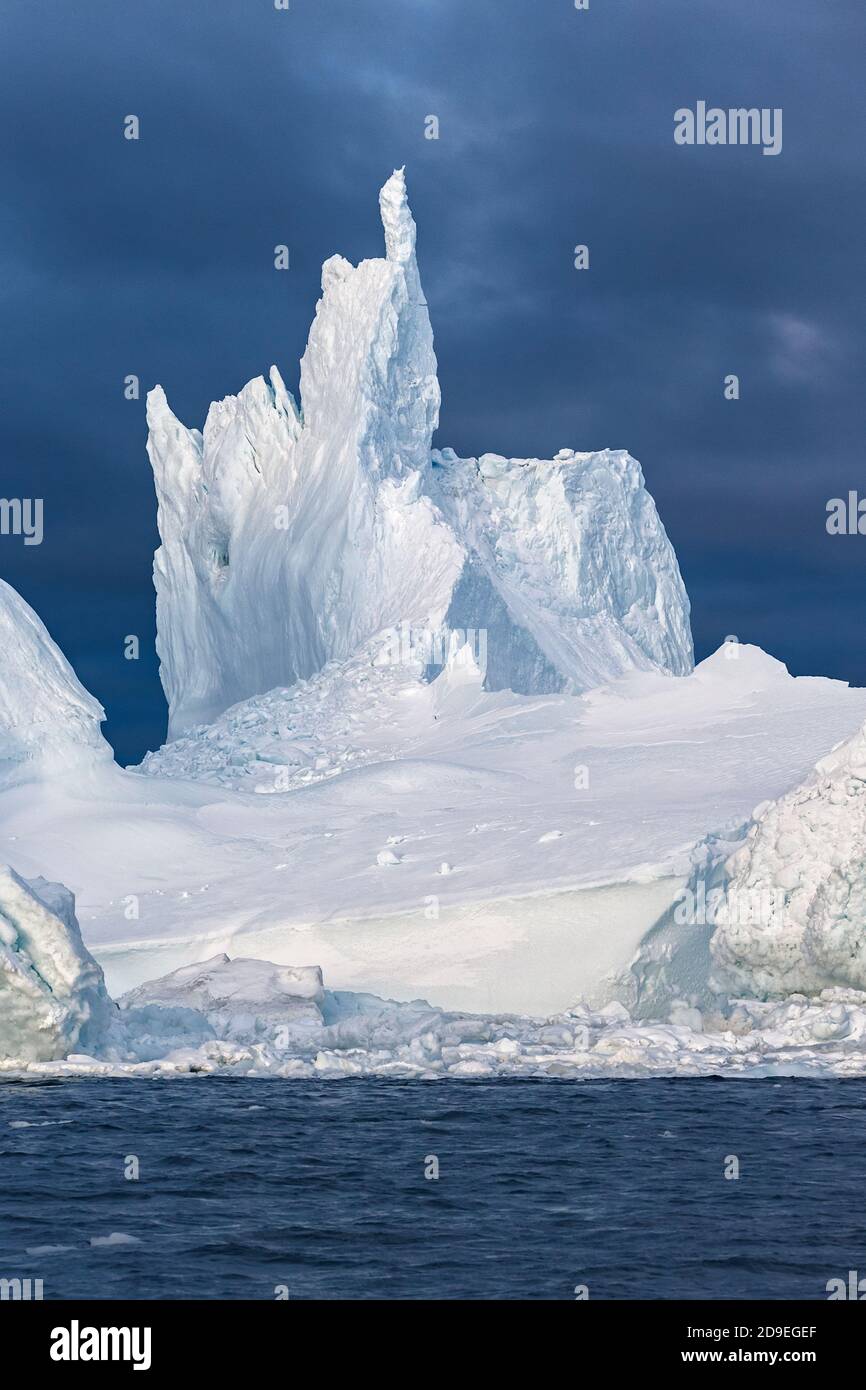 Colossale iceberg che naviga nell'oceano Artico. Il ghiaccio punta al cielo blu scuro. Ilulissat, Disko Bay, Groenlandia Foto Stock