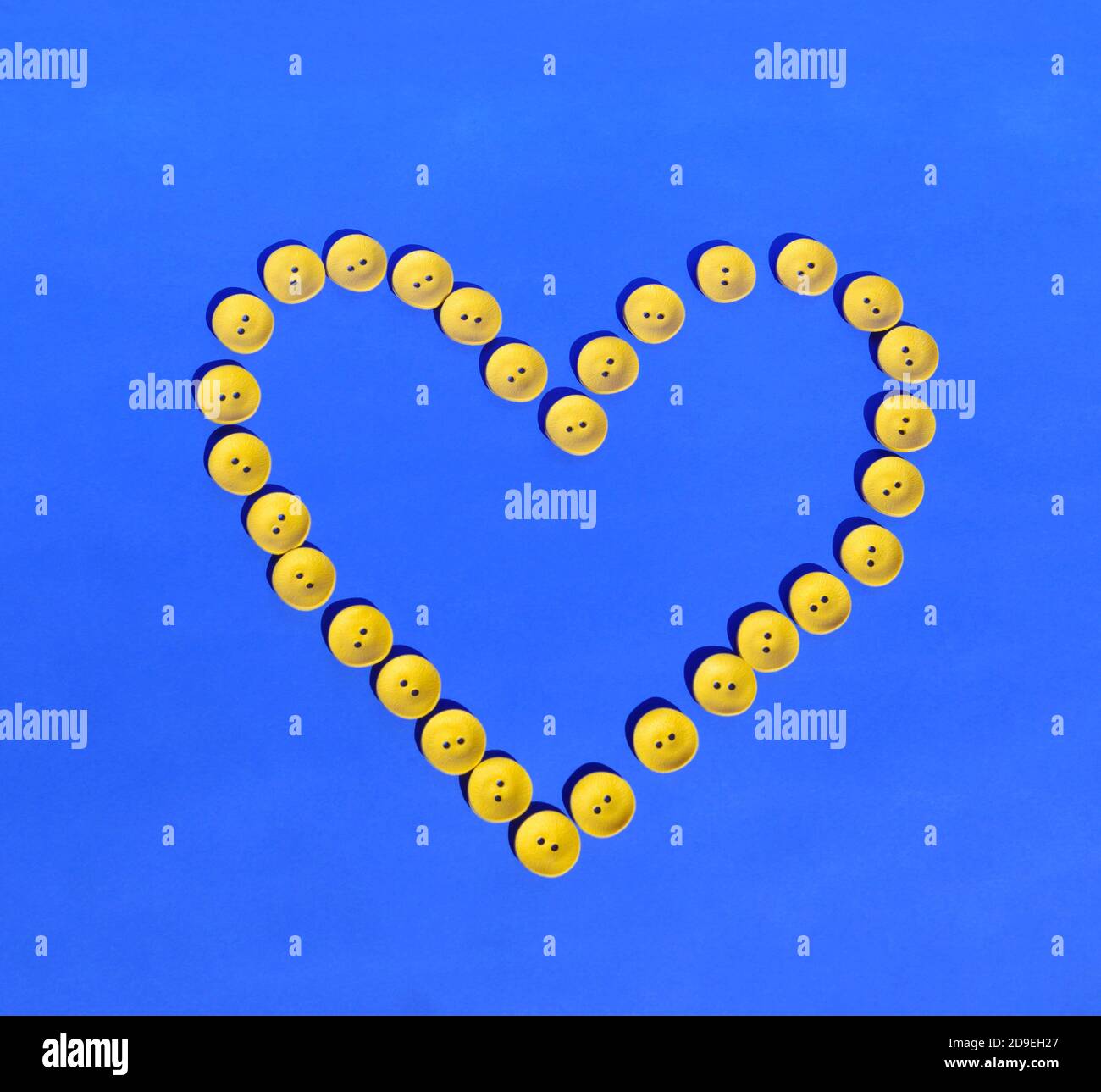 Su uno sfondo blu, un cuore di pulsanti. Il più affolgato. Lavoro di ago. Forniture per cucire. Spazio di copia. Foto Stock