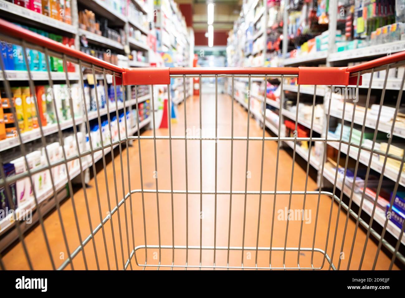 Vista prospettica carrello carrello carrello con corridoio supermercato sfondo sfocato Foto Stock