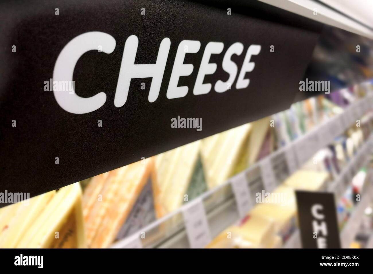 Segnaletica sul formaggio presso la sezione refrigerata del supermercato Foto Stock