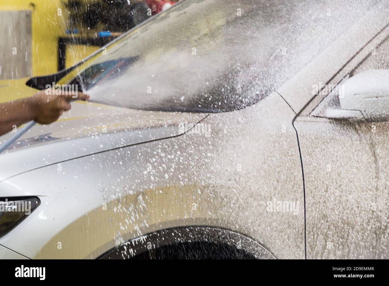 Operatore che spruzza schiuma detergente per sapone sull'auto per lavare  Foto stock - Alamy