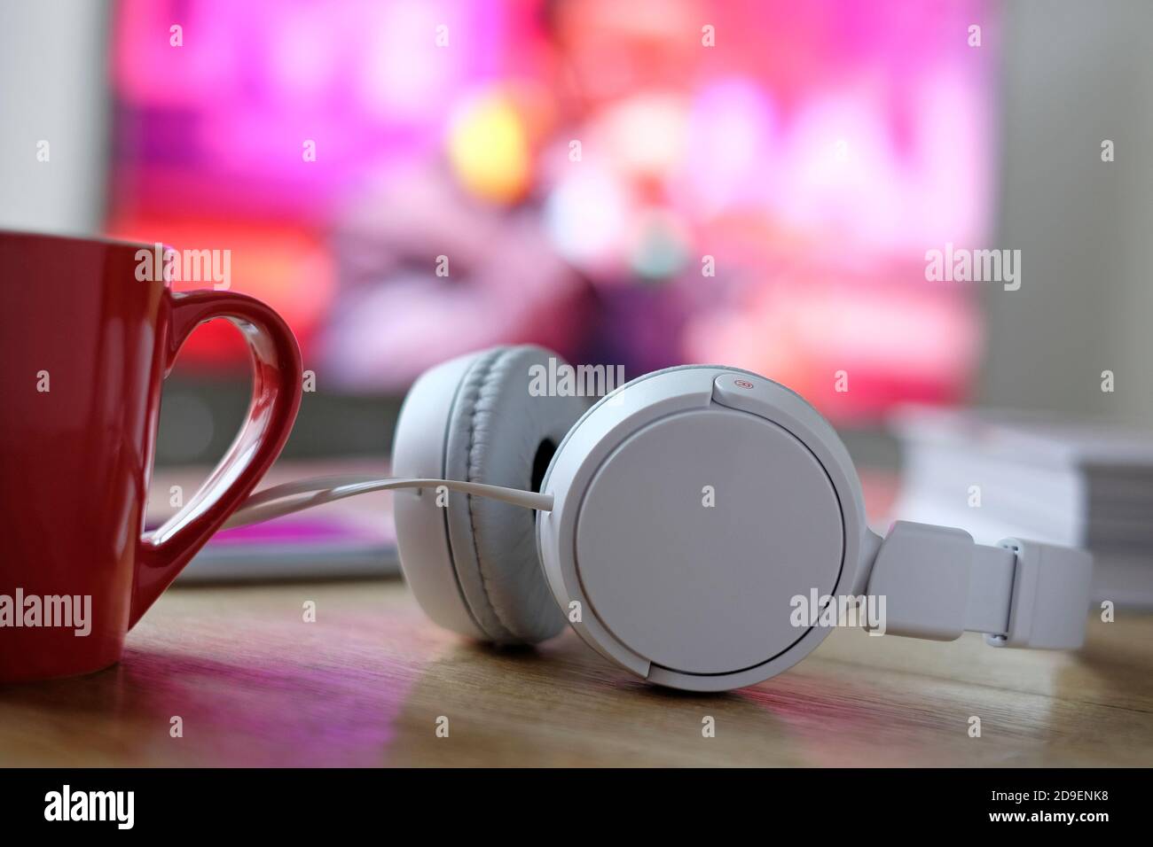 cuffie bianche con video musicali sullo schermo tv in background Foto Stock