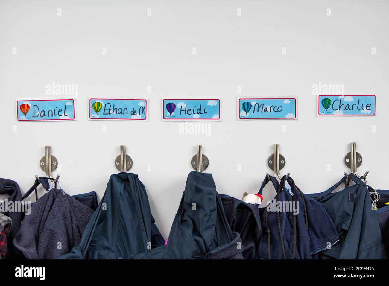 I nomi dei bambini sulle etichette sopra le borse e i cappotti fuori da un’aula in una scuola elementare del sud-ovest di Londra. 26 febbraio 2015. Foto: Neil Turner Foto Stock