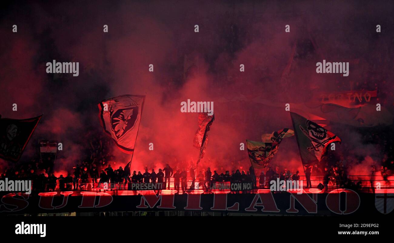 I tifosi di calcio dell'AC Milan sono bandiere d'onda e fiamme allo stadio di San Siro, a Milano. Foto Stock