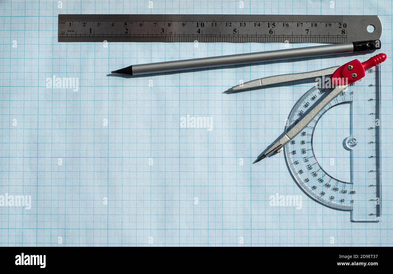 Telaio realizzato con accessori per calcoli e disegno su carta blu. Righello di protactor matita semplice e compassi. Scienze esatte. Foto Stock