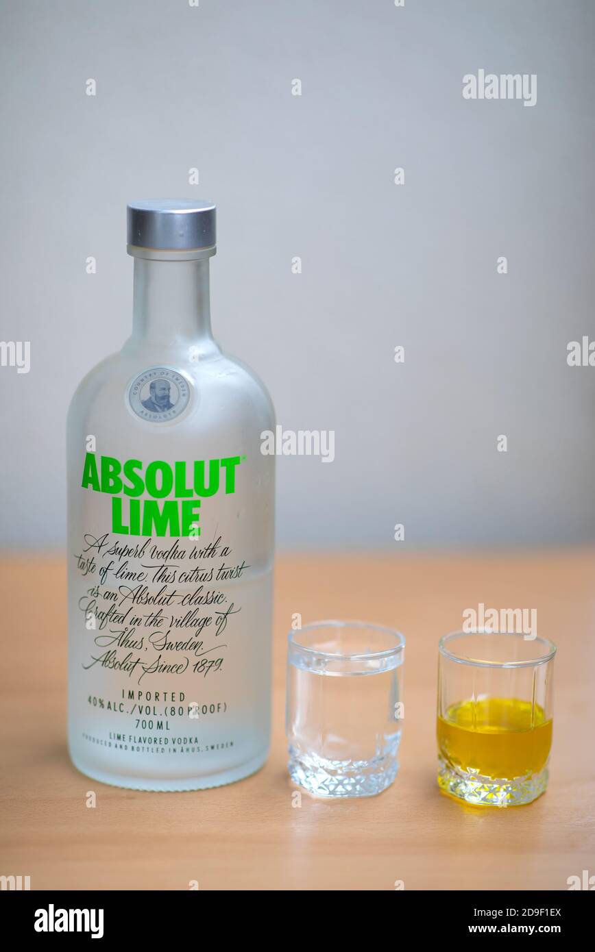 Una bottiglia di Absolut Vodka, un piccolo bicchiere di Absolut Vodka e olio sul tavolo di legno. Varsavia, Polonia. 05.11.2020 Foto Stock