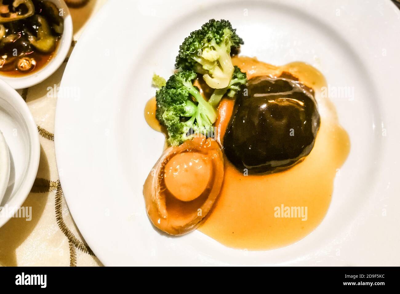 Brasato abalone con funghi e broccoli in salsa superiore Foto Stock