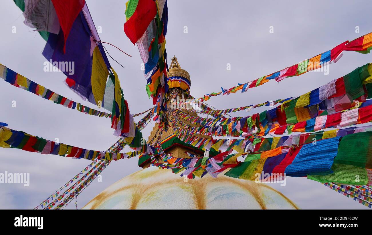 Bandiere colorate di preghiera buddista in cima alla famosa Boudhanath stupa (Boudha) nel centro di Kathmandu, Nepal, uno dei più grandi stupidi sferici del mondo. Foto Stock