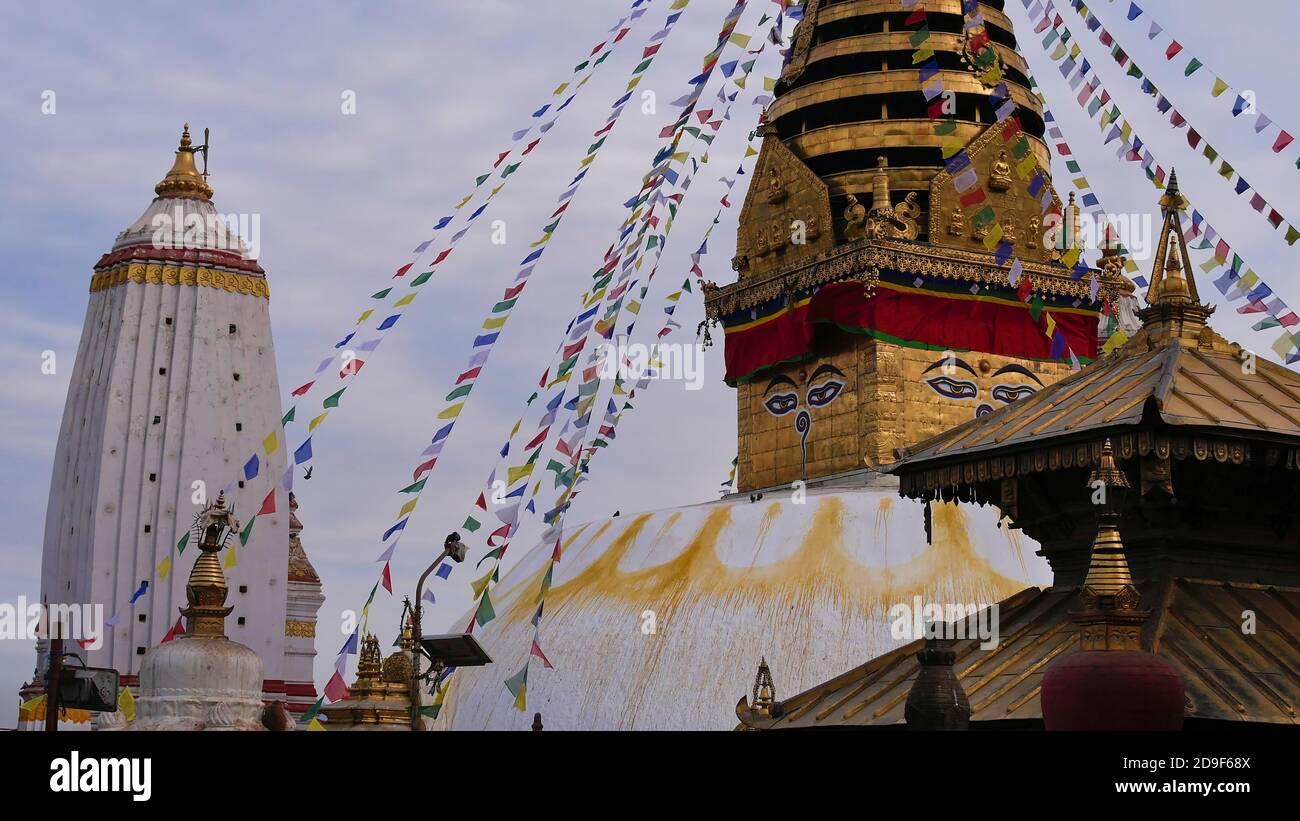 Vista in primo piano dei templi religiosi e uno stupa decorato con colorate bandiere di preghiera nel complesso del tempio buddista Swayambhunath situato su una collina. Foto Stock
