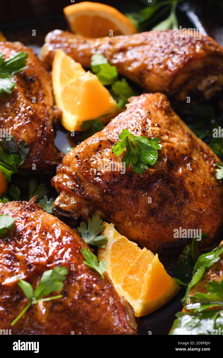 fette appetitose di pollo al forno con crosta fritta croccante e arance in una teglia Foto Stock