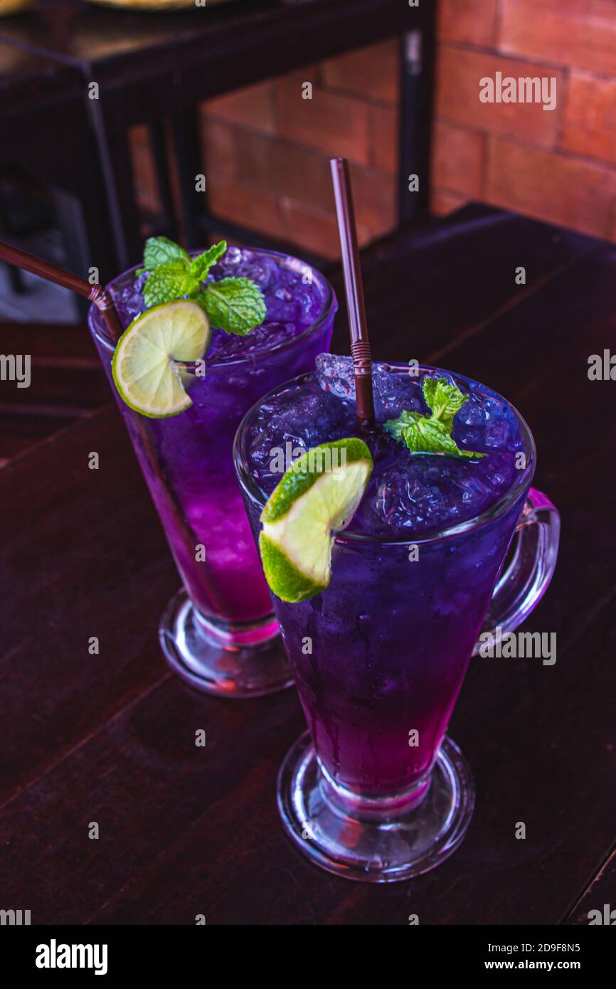 Butterfly pisello succo mix limone sono thai erbe bevanda per la salute e rinfrescare in vetro chiaro due messo su tavolo di legno marrone scuro. Selezionare fuoco. Foto Stock