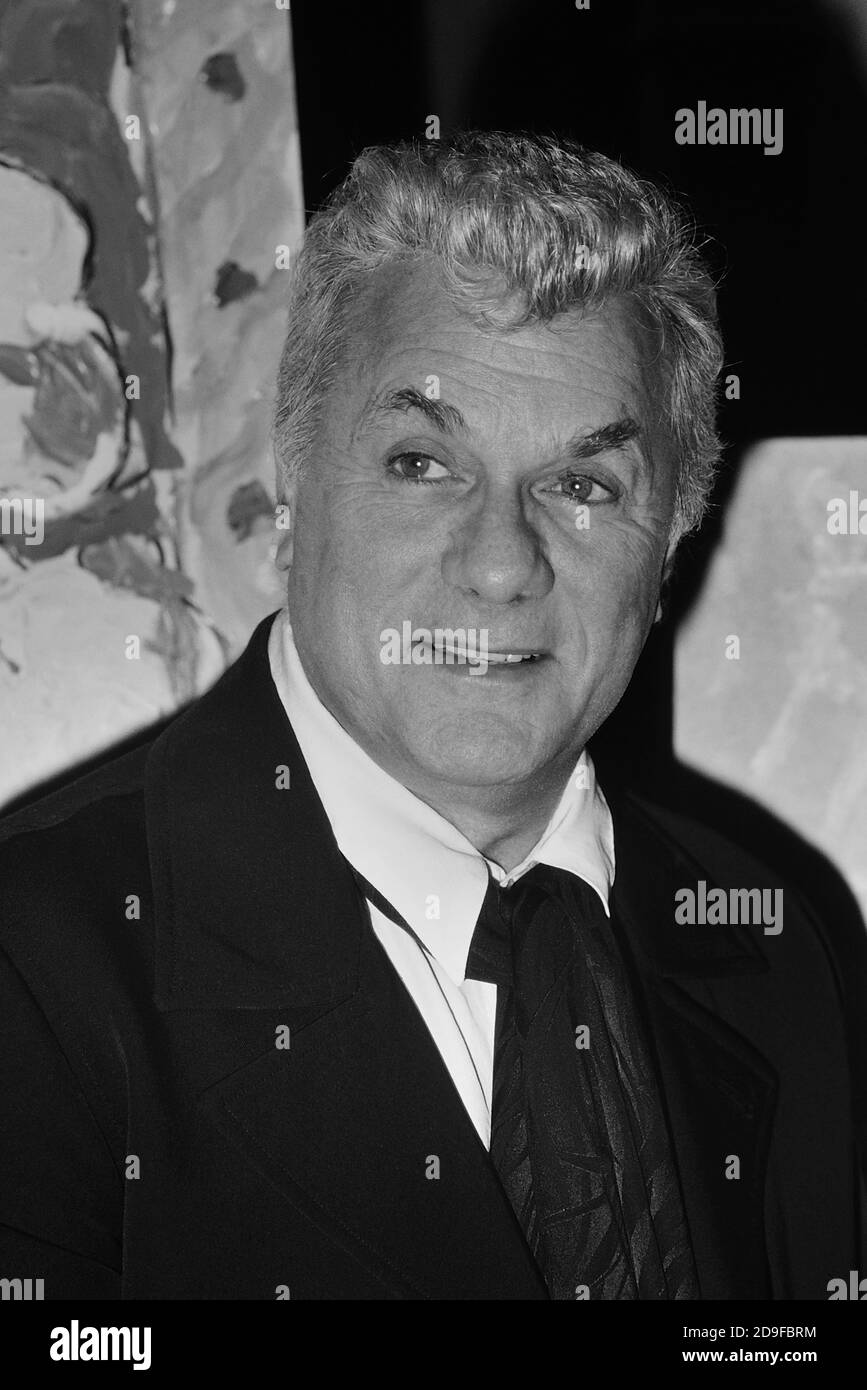 La leggenda di Hollywood, Tony Curtis, (3 giugno 1925 – 29 settembre 2010) in posa con una selezione dei suoi quadri d'arte. Mayfair Hotel, Londra, Inghilterra, Regno Unito circa anni '80 Foto Stock