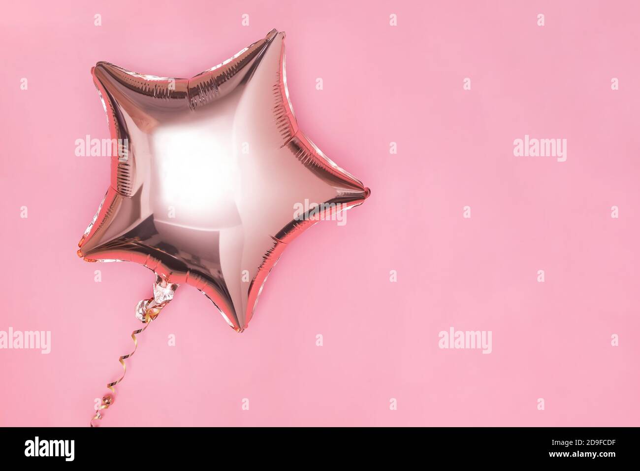 Palloncino a forma di stella con glitter oro isolato su rosa Foto Stock