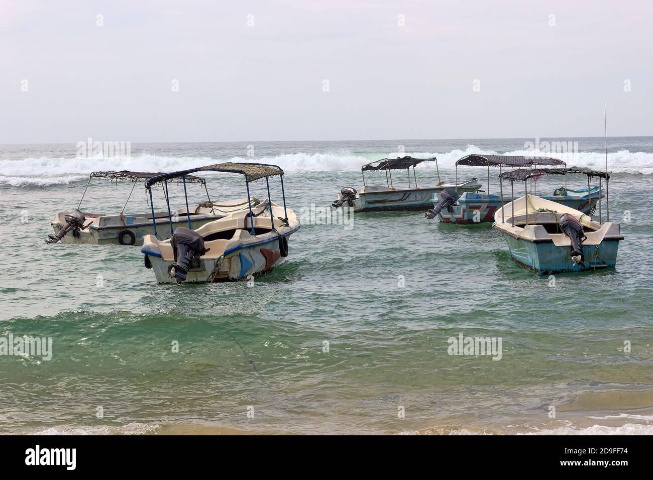 Attività ricreative acquatiche. Barche da diporto sulla spiaggia nella zona surf e scogliera. Mare di Laccadive Foto Stock