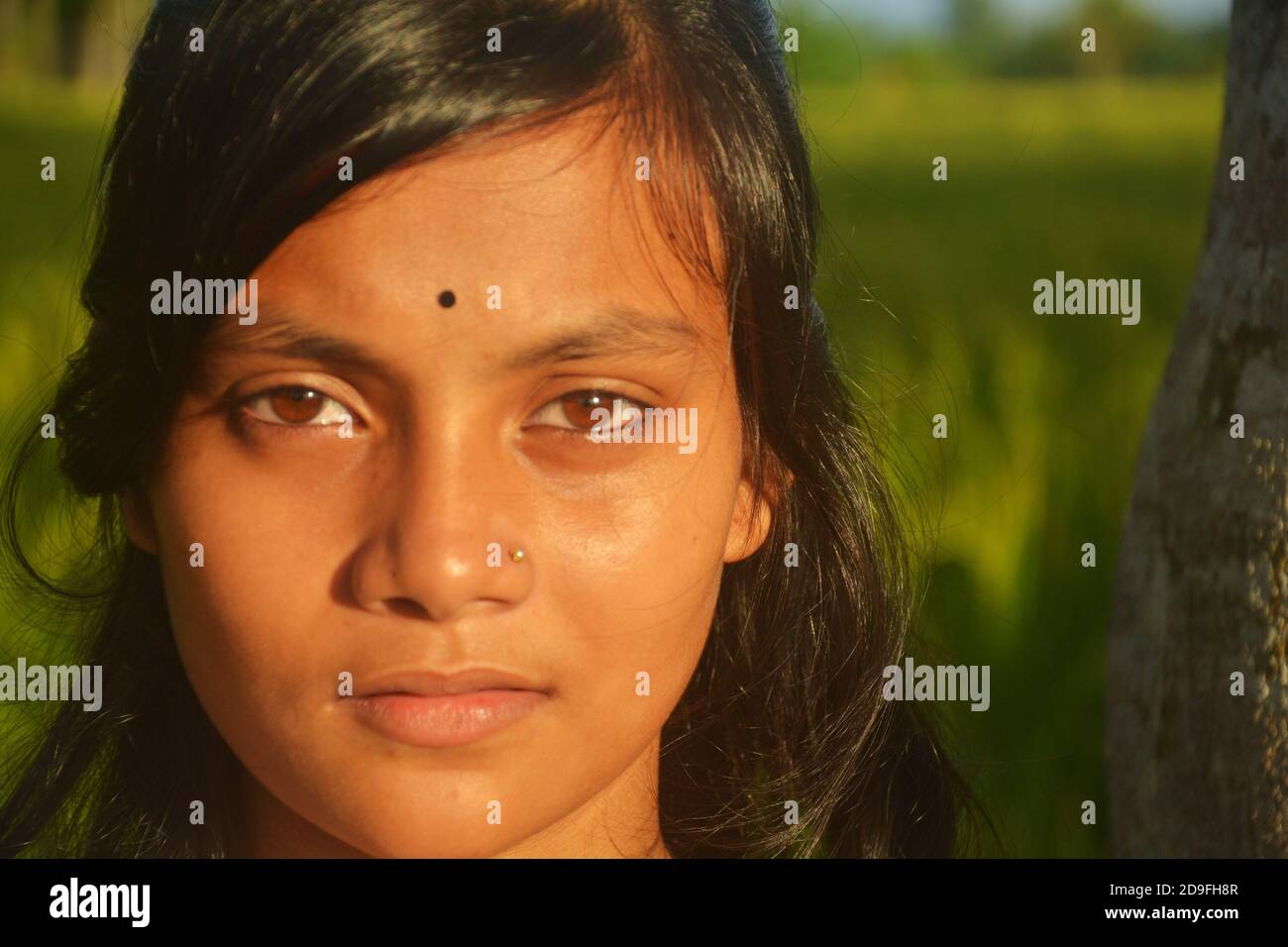 Primo piano di una ragazza adolescente indiana che indossa il naso pin bindi sulla fronte con lunghi capelli scuri, messa a fuoco selettiva Foto Stock