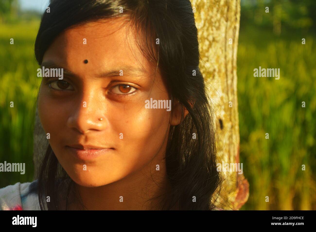 Primo piano di una ragazza adolescente indiana che indossa il naso pin bindi sulla fronte con lunghi capelli scuri, messa a fuoco selettiva Foto Stock