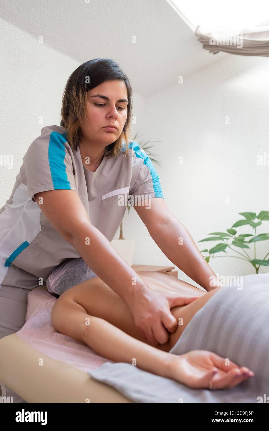 Donna caucasica che riceve un massaggio della colonna vertebrale nel salone termale Foto Stock