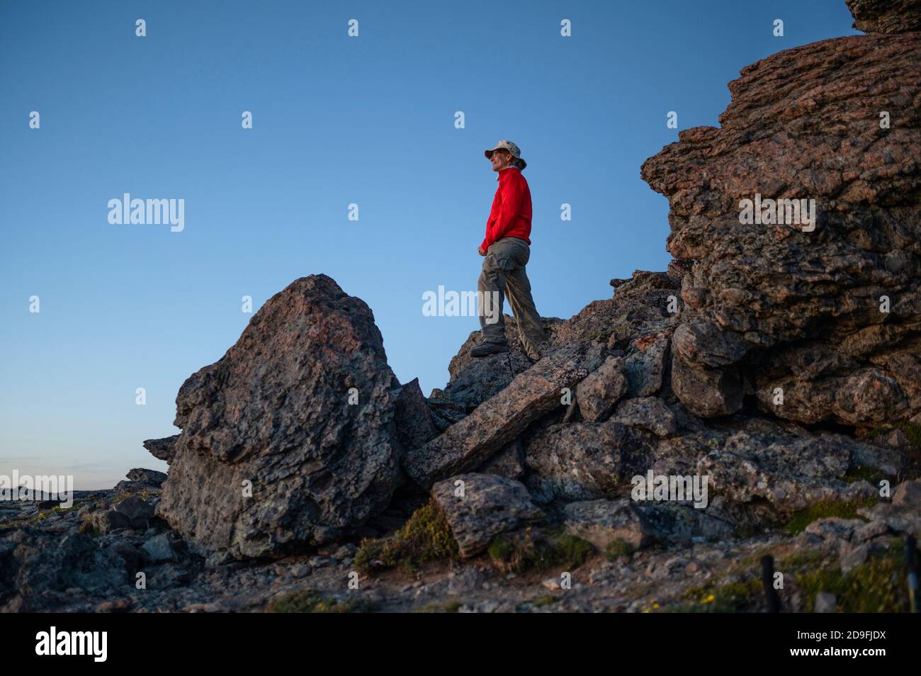 Uomo che guarda fuori all'orizzonte mentre si sta in piedi su rocce Foto Stock