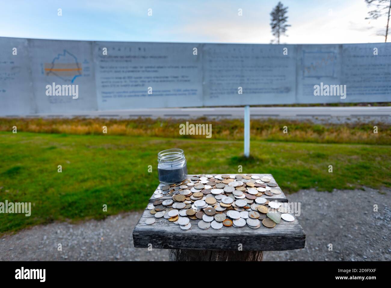 Monete da diversi paesi lasciate dai turisti come un segno di memoria vicino al Circolo polare artico bordo nel comune di Overkalix, Norrbotten County, Svezia Foto Stock