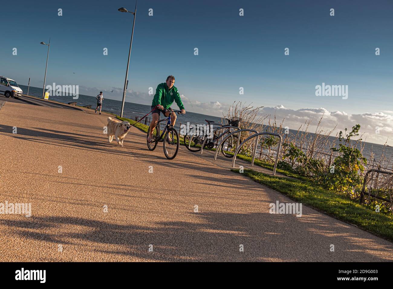Vita quotidiana. Uomo in bicicletta con il cane lungo il mare. Foto Stock