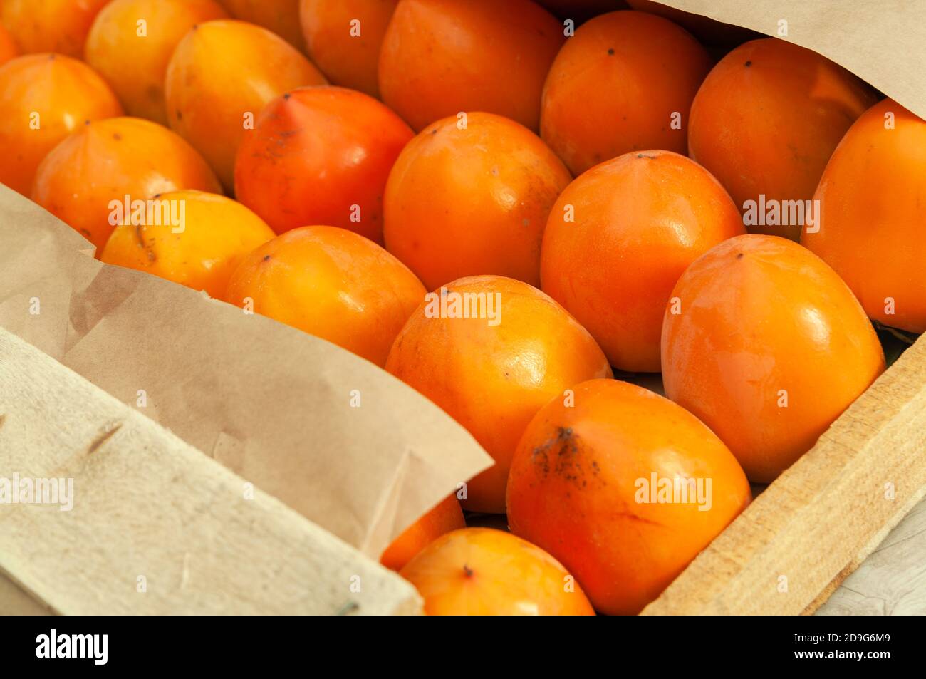 Persimmons freschi biologici maturi in una scatola di legno prima della spedizione al mercato. Primo piano. Foto Stock