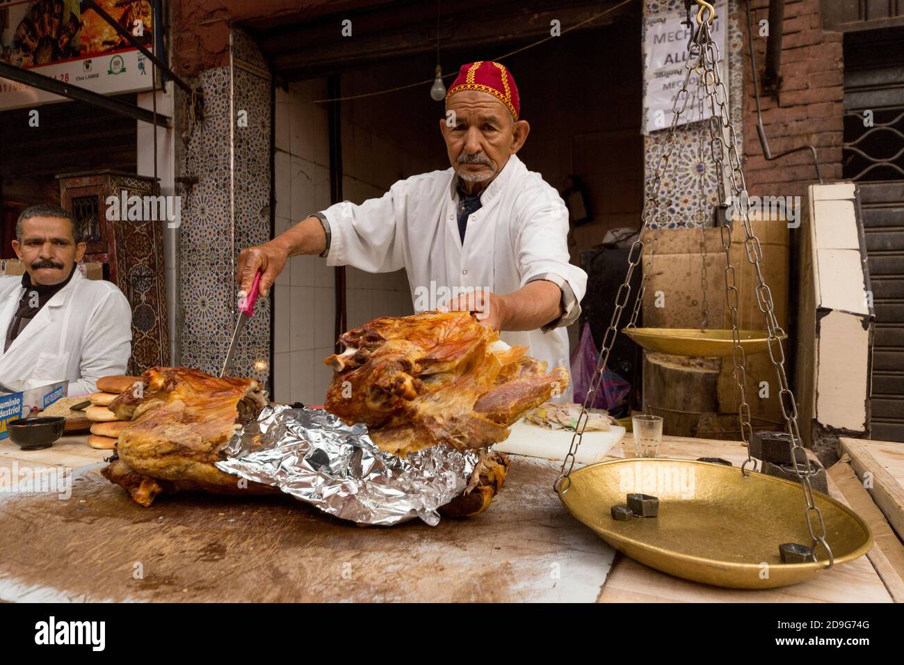 Uomo che vende mechoui (agnello a cottura lenta) nel souk di Marrakech, Marocco. Foto Stock