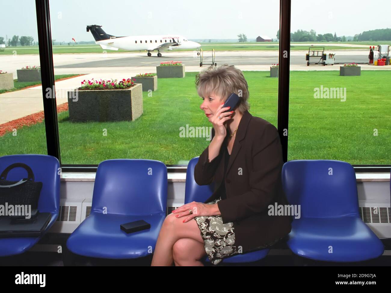 Donna professionale lavora con PDA computer e cellulare in attesa di un volo in aeroporto Foto Stock
