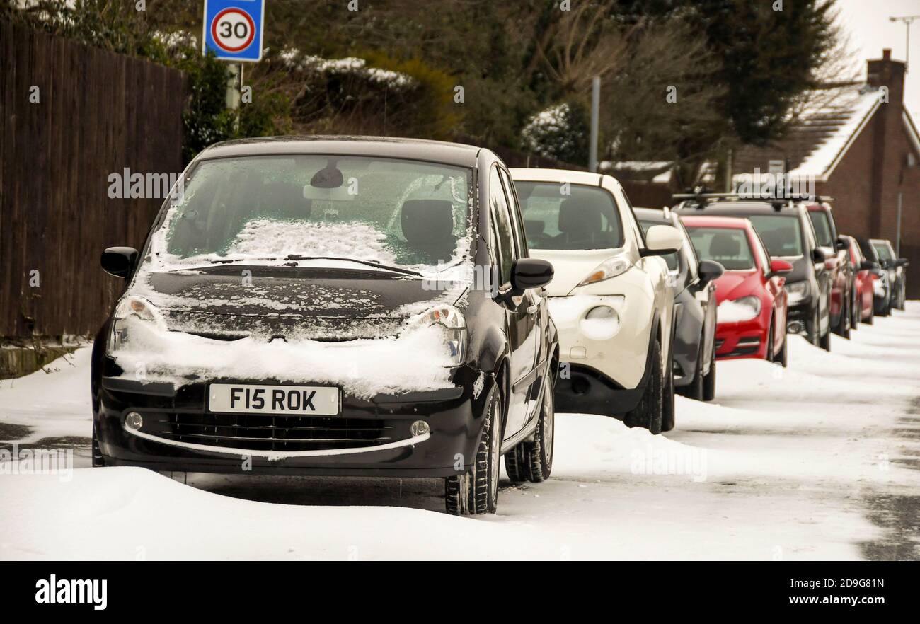 Pontypridd, Galles - Marzo 2018: Le auto sono lasciate sul ciglio della strada dopo una caduta di neve, con dridi neve tra le vetture Foto Stock
