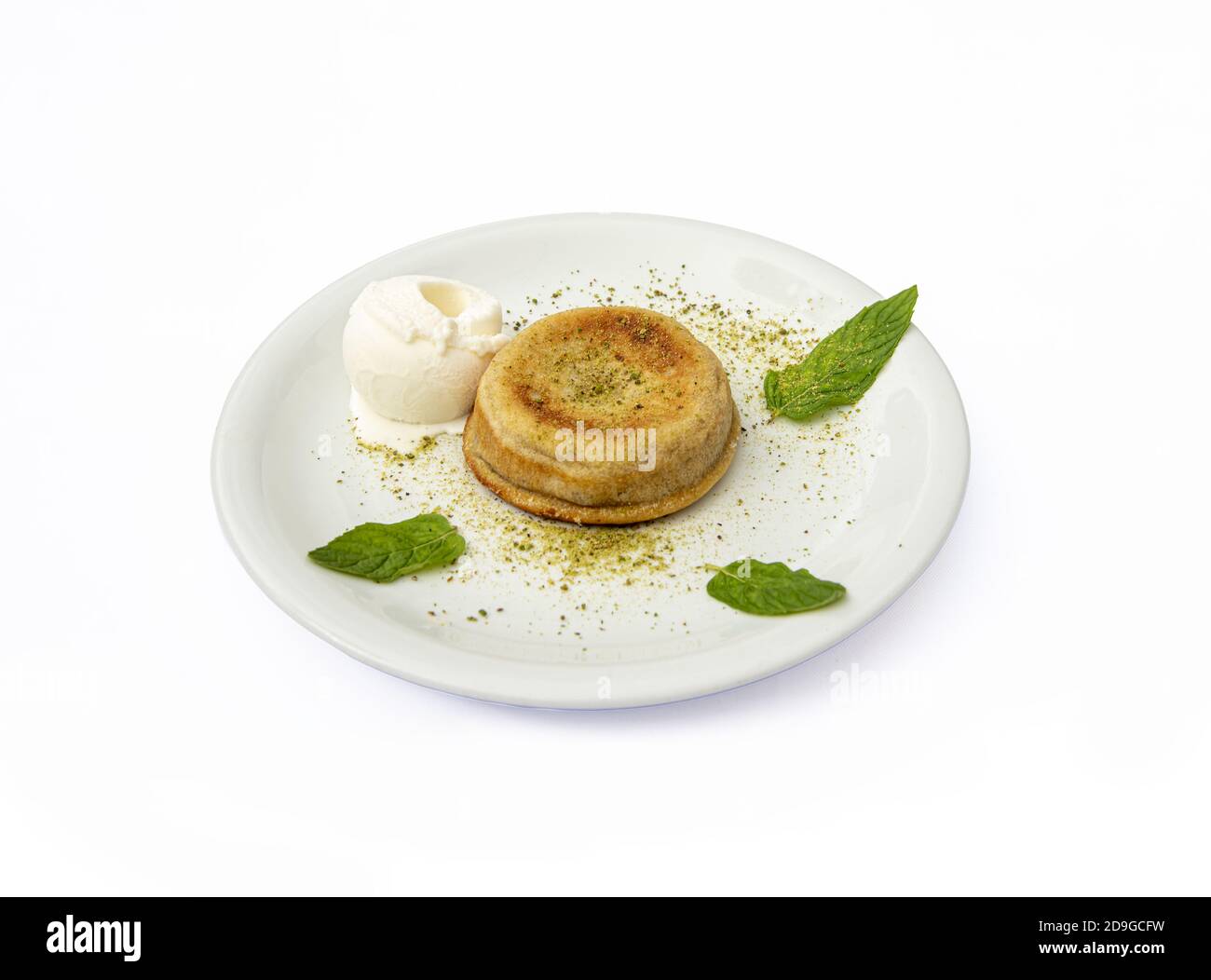 Primo piano di un dessert di semola con gelato servito una piastra bianca isolata su sfondo bianco Foto Stock