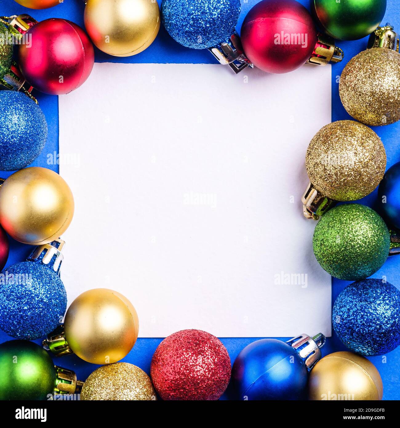 Composizione natalizia con spazio di copia quadrato bianco. Ornamento colorato e decorazioni baubles. Modello di biglietto di auguri mockup Foto Stock