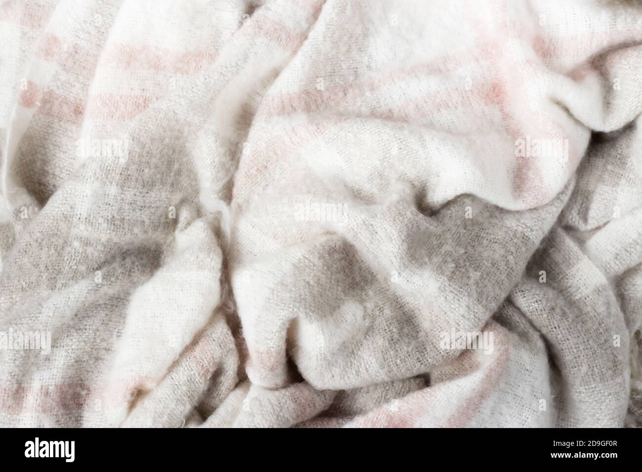 Coperta di lana grigia sminuzzata. Tessuto morbido e caldo sminuzzato in pieghe. Texture d'autunno o d'inverno Foto Stock