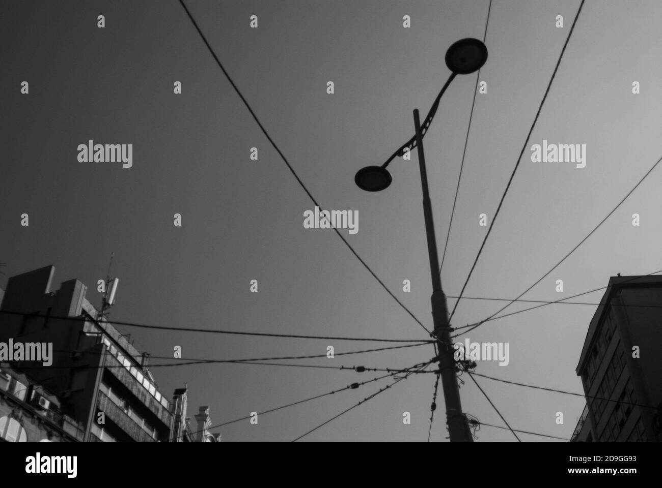 Immagine in scala di grigi di un palo per illuminazione stradale con fili Foto Stock
