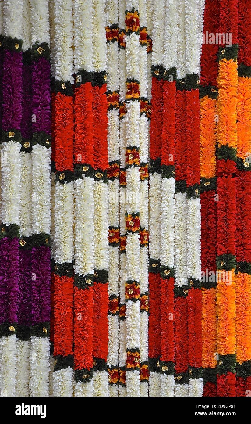 Colorati ghirlande di fiori in vendita, appesi in un negozio indiano. Foto Stock