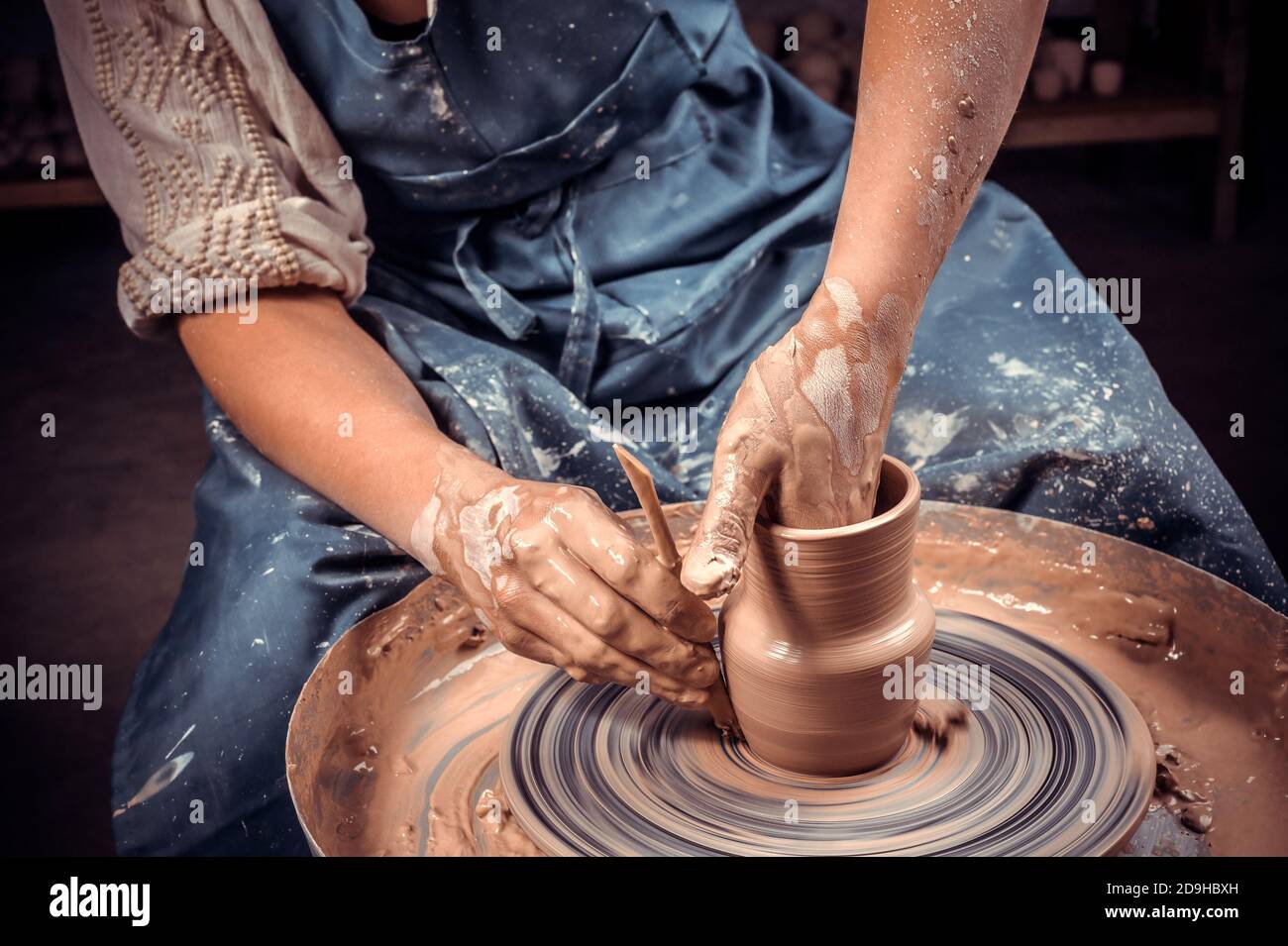 Scultore artigiano lavora con argilla sulla ruota di un vasaio e al tavolo  con gli attrezzi. Arte ceramica concetto. Primo piano Foto stock - Alamy