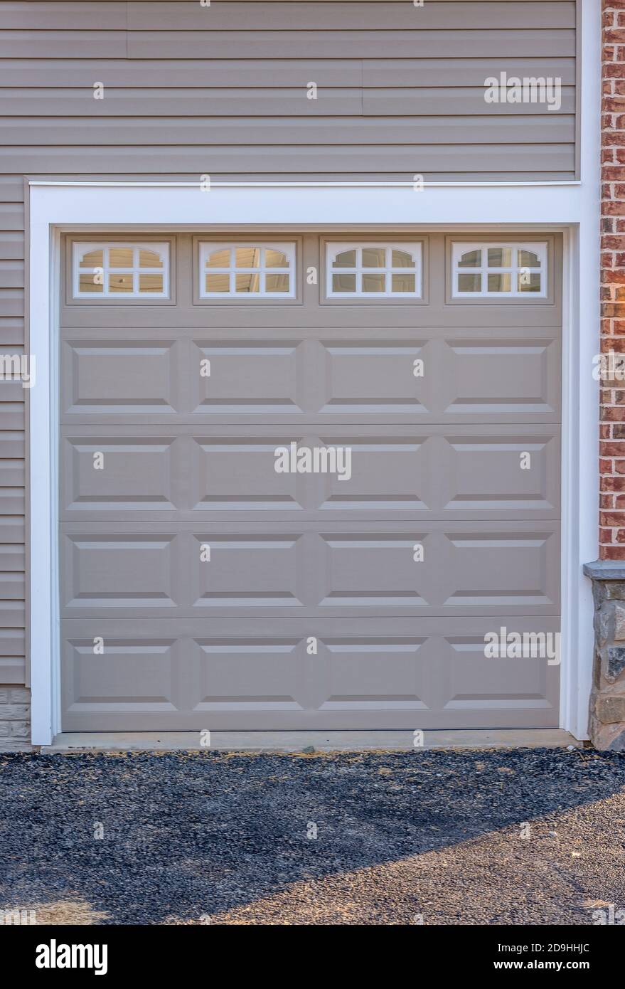 Auto singola grigio carbone classico isolato in acciaio pannello rialzato porta garage incorniciato con un rivestimento bianco per aggiungere accento, con luce di poppa finestre diviso b Foto Stock