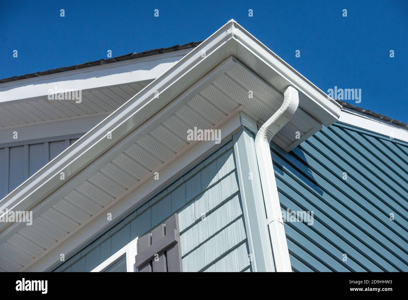 Sistema di protezione per grondaia bianco coloniale, fascia, bordo di gocciolamento, soffit che fornisce la ventilazione alla soffitta, con pacific blu shingle siding casa di lusso Foto Stock