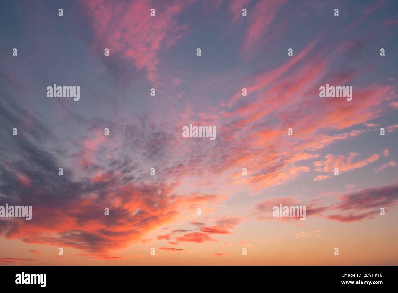 I caldi raggi solari del tramonto colpiscono le nuvole Una serata d'autunno Foto Stock