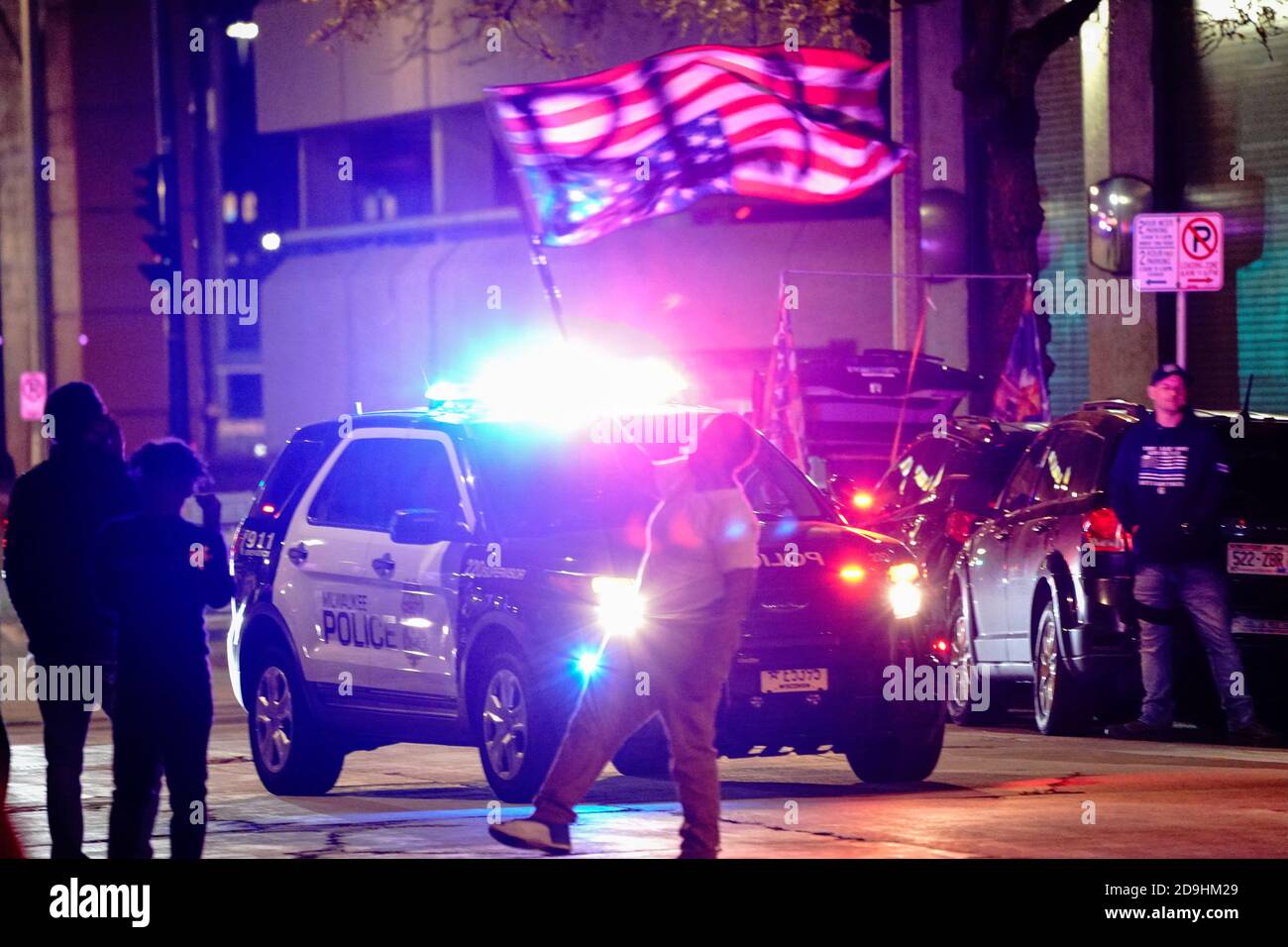Un controprotestore Black Lives Matter (BLM) fa ondeggiare una bandiera americana capovolta mentre i sostenitori di Trump guardano a una protesta di 'Stop the Steal' fuori del conte centrale di Milwaukee il giorno dopo che la contea di Milwaukee ha finito di contare i voti degli assenti, a Milwaukee, Wisconsin, Stati Uniti, il 5 novembre 2020. REUTERS/Bing Guan Foto Stock