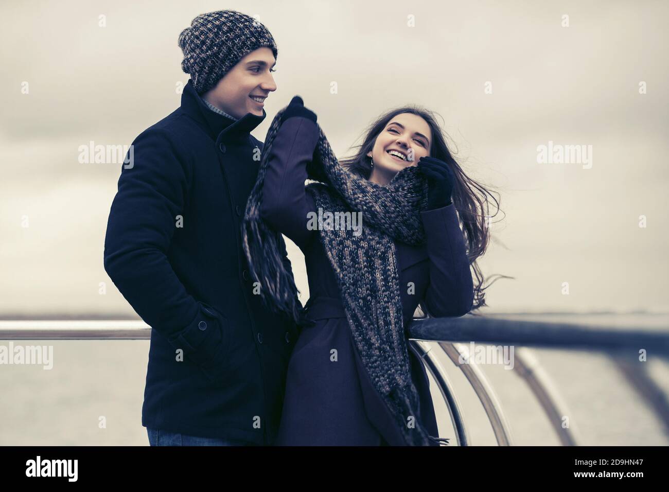 Felice giovane coppia di moda in amore di divertirsi all'aperto elegante uomo e donna in cappotti classici, bania e sciarpa Foto Stock