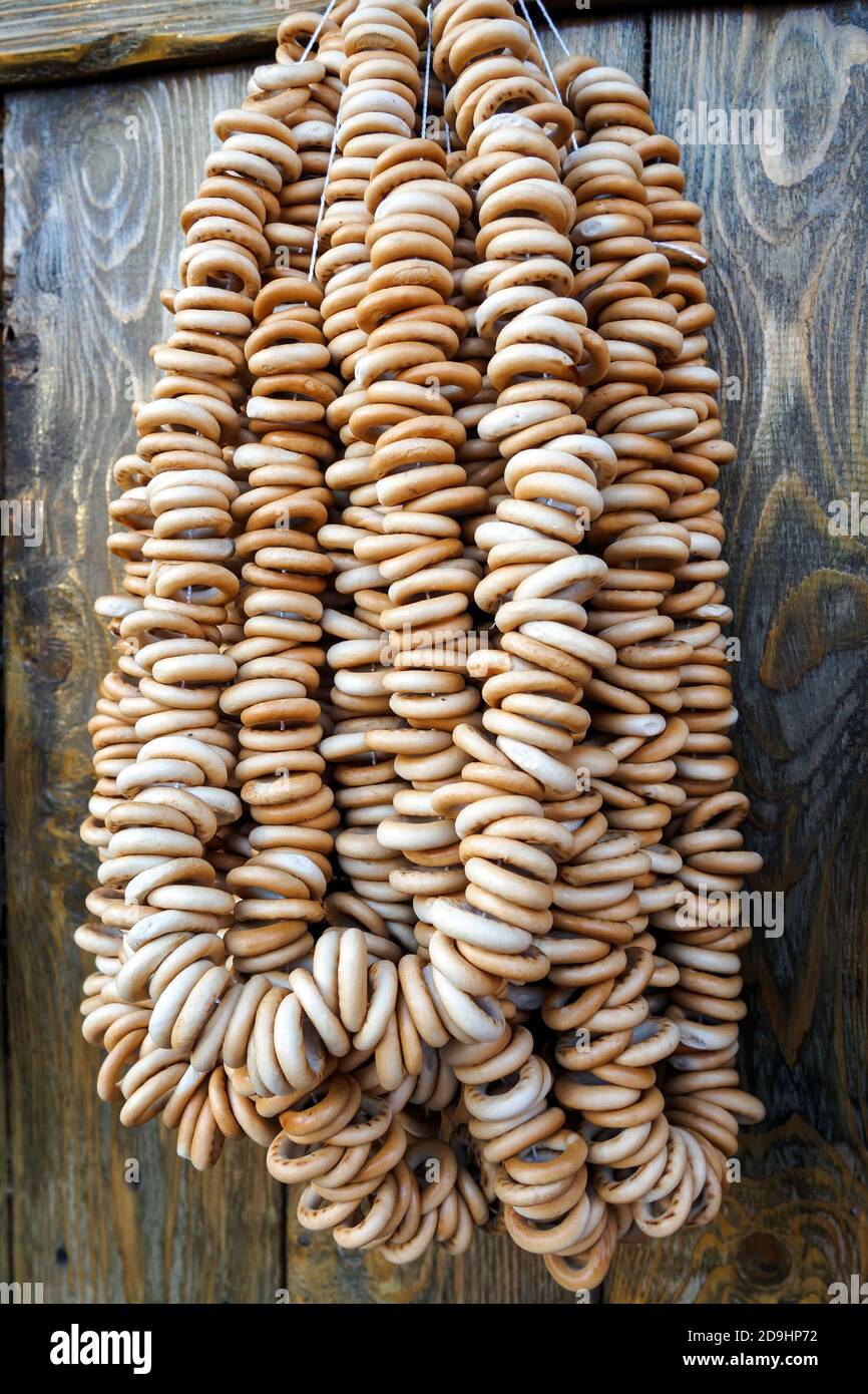 Un sacco di bagel sulla corda pendono su pareti di legno, vista verticale. Foto Stock