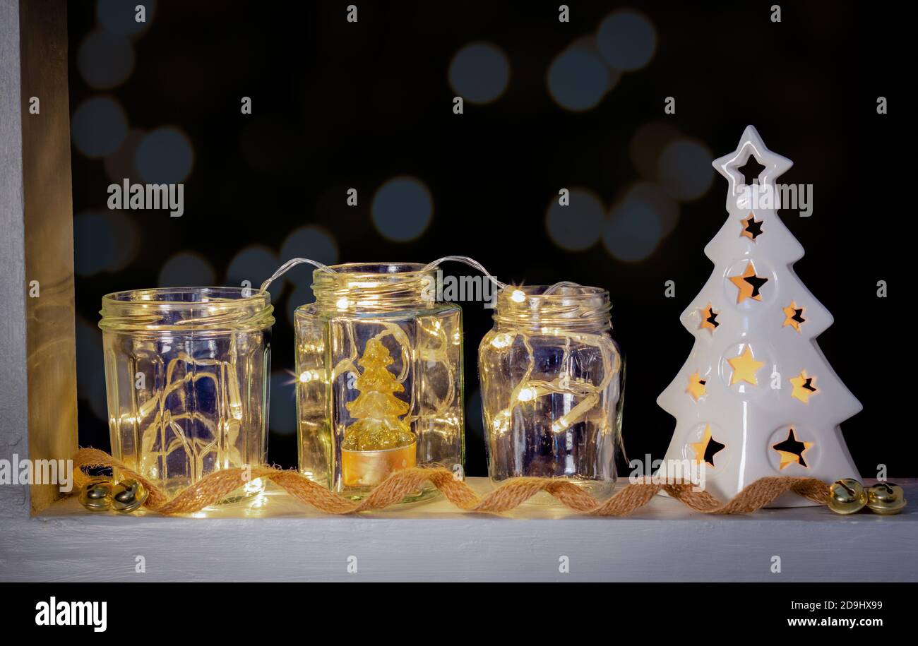 Fairy luci in vasi riciclati riutilizzati come festive finestre decorazione, fuoco selettivo. Vacanze sostenibili e Natale. Foto Stock