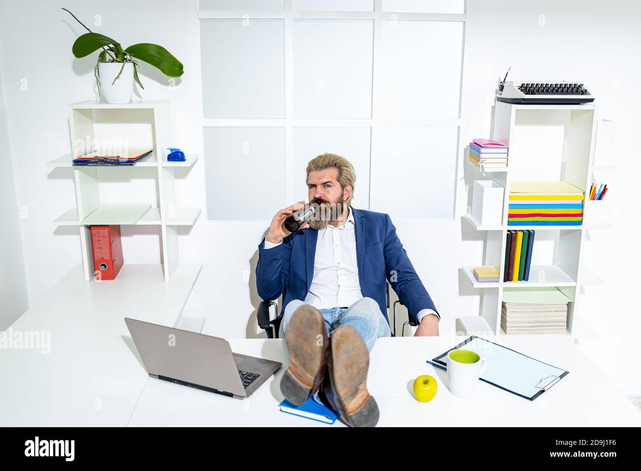 Uomo manager uomo d'affari ha lavorato con successo e alla fine della giornata, bevande birra. Foto Stock