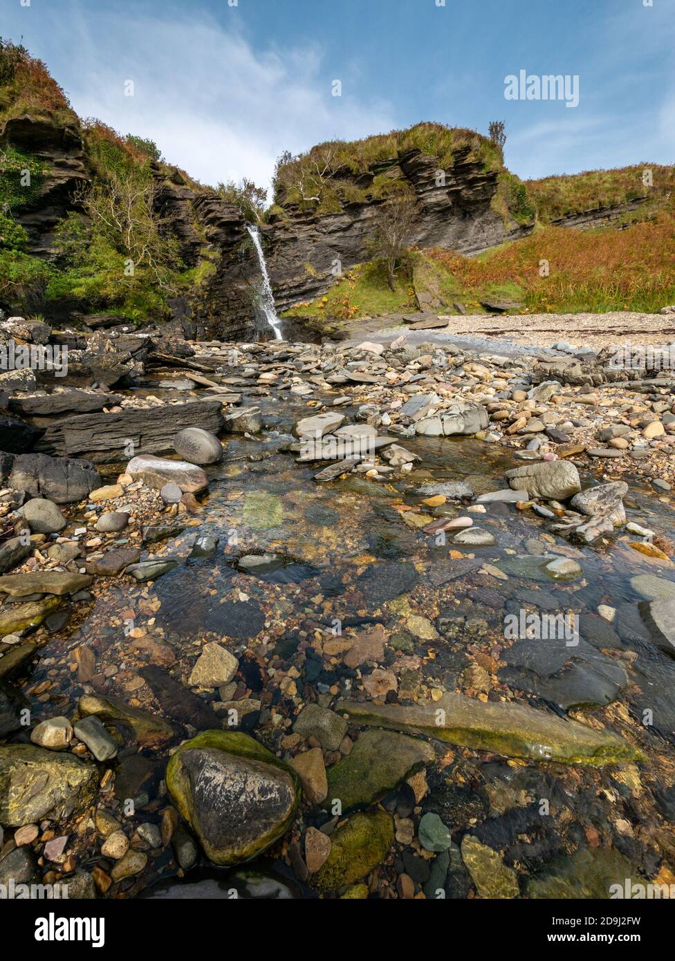 Cascata sul Allt na Pairte fiume come si immerge su scogliere sul mare in una piscina a Boreraig, Isola di Skye, Scotland, Regno Unito Foto Stock