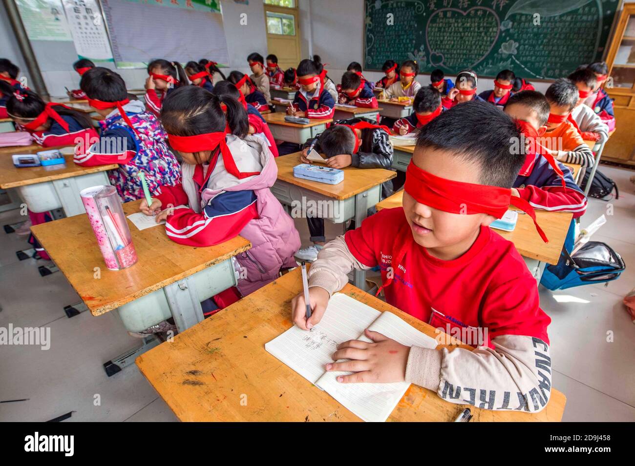 I bambini si bendano facendo attività per dare il benvenuto alla Giornata Internazionale dei ciechi in una scuola nella città di Qingzhou, nella provincia di Shandong, nella Cina orientale, Foto Stock