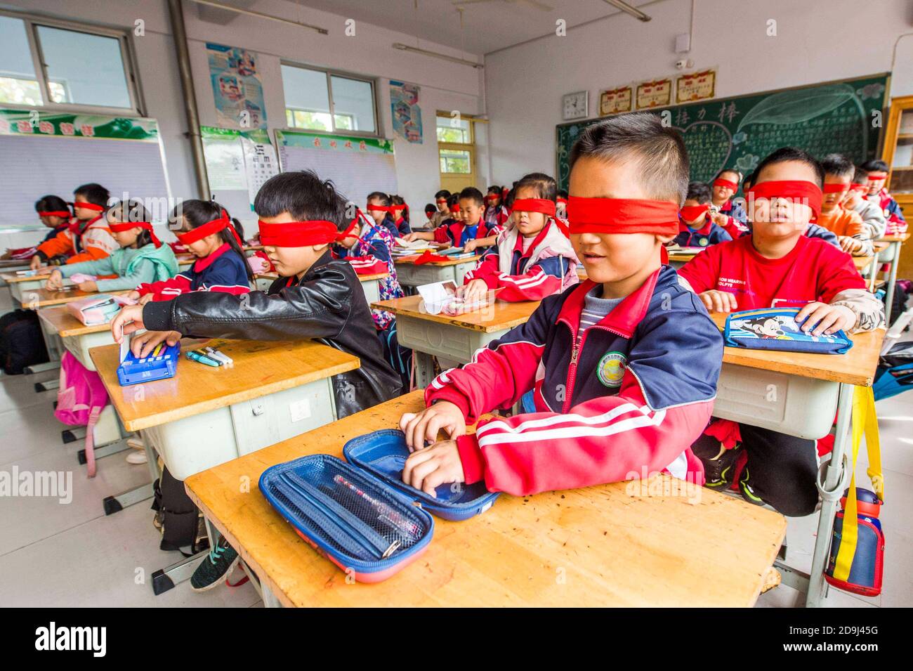 I bambini si bendano facendo attività per dare il benvenuto alla Giornata Internazionale dei ciechi in una scuola nella città di Qingzhou, nella provincia di Shandong, nella Cina orientale, Foto Stock