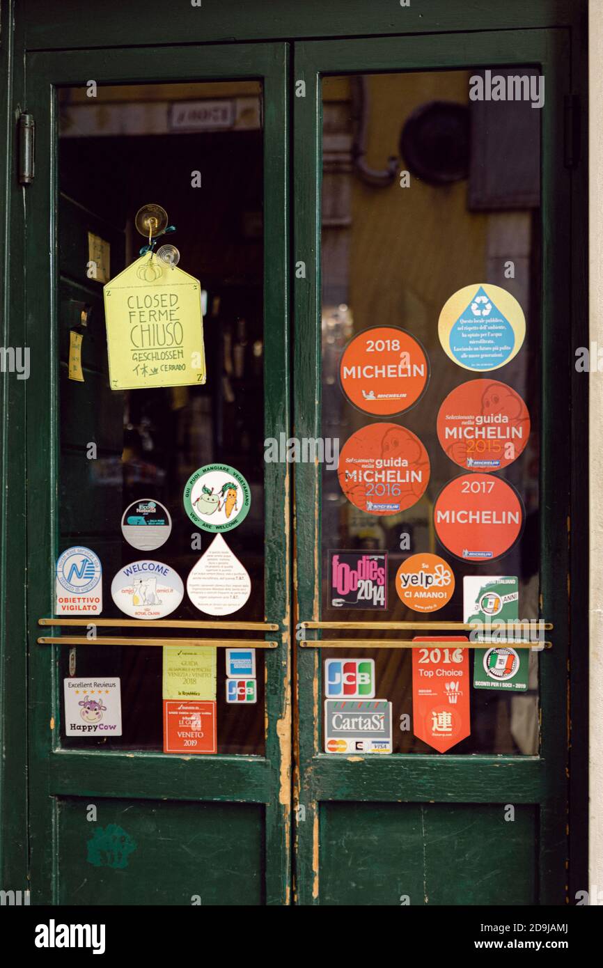 Porta del ristorante veneziano con cartelli appiccicosi Foto Stock