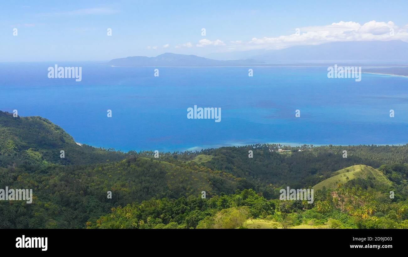 La costa dell'isola di Mindanao è coperta di foresta pluviale, con spiagge e mare blu. Filippine, Mindanao. Foto Stock